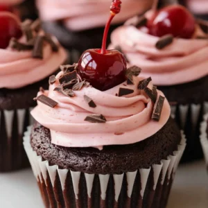 Delicious cherry chocolate cupcakes topped with cherry frosting and chocolate sprinkles