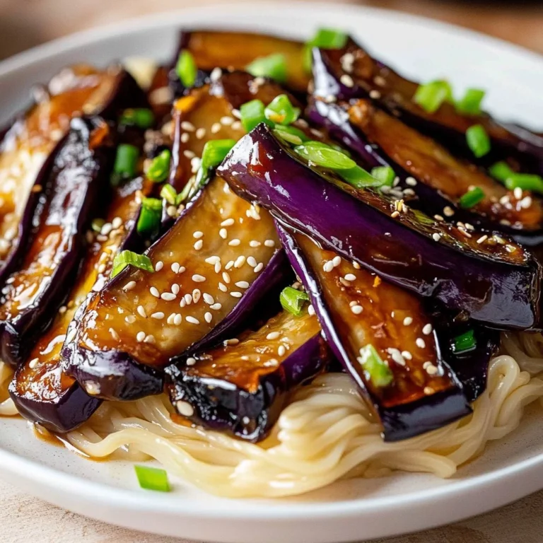 A vibrant garlic eggplant stir fry served in a pan, garnished with herbs.